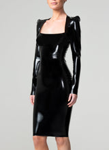 A model on a grey background wearing a shiny black latex pencil dress with a square neckline and long sleeves.