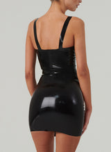 Back shot of a model wearing a black latex mini dress with wide shoulder straps.