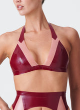 A plum latex bikini-style halter bra with Semi-Transparent pink inserts. The model wears the matching latex lingerie set.