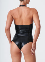 Back view of a model wearing a shiny black latex halter neck body suit.