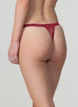 Back view of a model wearing plum latex thong.