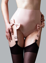 High waisted baby pink latex knickers with four adjustable suspender straps attached and bows at the front, worn with black stockings.