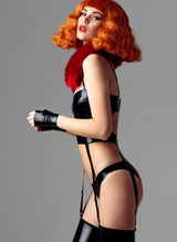 A model wearing black latex lingerie and fingerless mittens with bright orange hair and a red fur collar, on a grey background.
