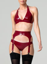 A model wearing a plum latex rubber lingerie set, including halter neck bikini-style bra, four strap suspender belt and hipster briefs. Black stockings also shown, all by designer William Wilde.