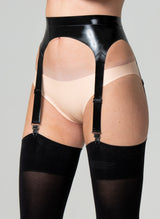A person wearing a black latex suspender belt with four adjustable straps, paired with pale peach latex hipster briefs and black stockings.