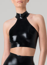 A person wearing a black latex halter neck cropped top with a choker collar.