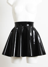 A black latex circle skirt with fitted waistband, on a mannequin.