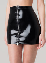 A person wearing a black latex mini skirt with a silver metal zip at front.
