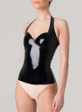 A model wears a black latex halter neck top with sweetheart neckline, and peach latex knickers.
