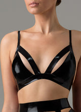 A shiny black latex bra with strap detail and cut aways at bust. Worn with matching suspender belt.