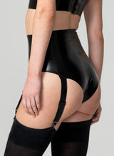 A model form behind, wearing high-waisted black latex knickers with four adjustable suspender straps. Worn with black stockings. The image shows the person from the waist down, focusing on the garment.