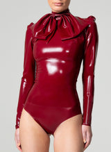 A long-sleeved plum latex blouse with a high collar and gathered sleeve heads. Large Pussy Bow is worn at the neck, but not attached. Worn here with matching plum latex knickers.