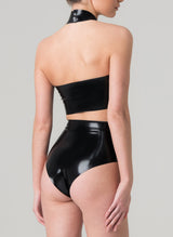 back view of a model on a grey background wearing a glossy black latex halter neck cropped top and high-waisted latex knickers.