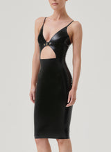 A model wearing a black latex pencil dress with a front cutout and gold buckle detail, with adjustable shoulder straps.