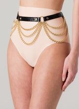 A black leather belt with gold chains and rings, worn over peach latex high-waisted knickers.