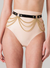 A black leather belt with gold chains and rings, worn over peach latex high-waisted knickers.