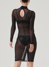 Back view of a model wearing a black mesh pencil dress with long sleeves, a high neck, and a keyhole at back, paired with black latex lingerie, visible underneath.